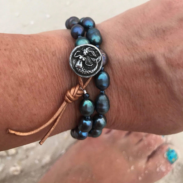 This image portrays Gogh Jewelry Design - Mermaid Soul - Pearl and Leather Wrap Bracelet with Mermaid Button by Scuba Show | June 1 & 2, 2024.